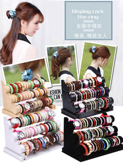 Close-up of watches and bracelets displayed on velvet stand