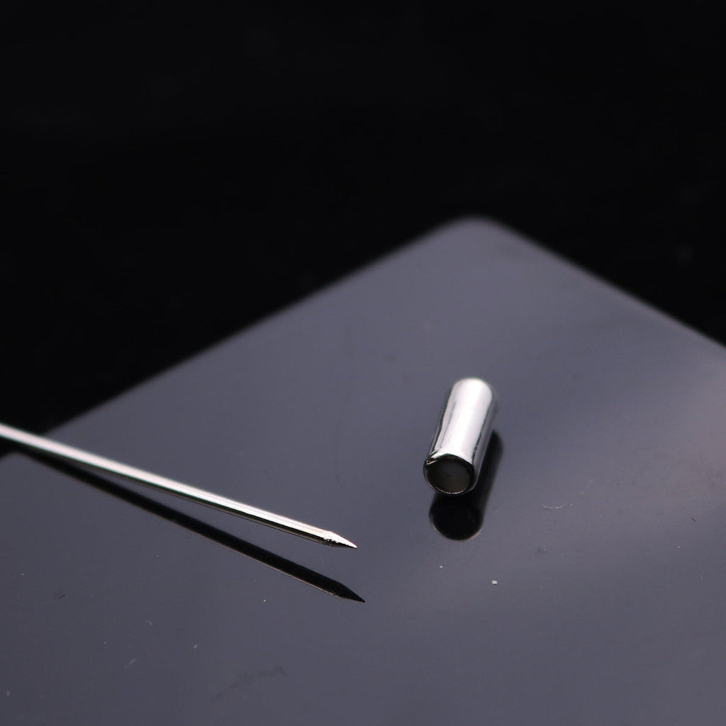 Silver feather lapel pin displayed on fabric