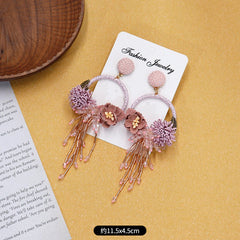 Colorful floral earrings displayed on neutral background