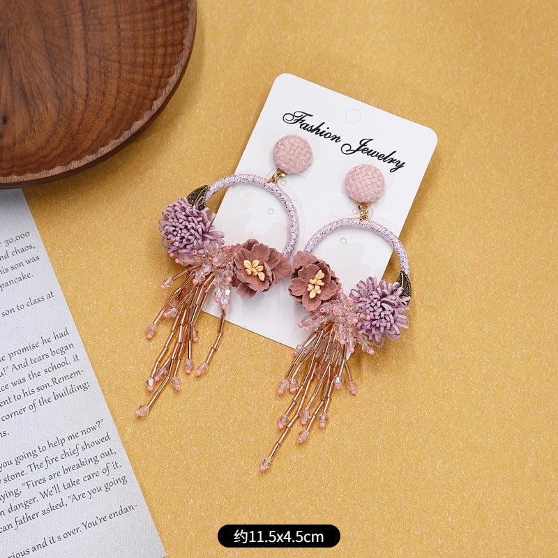 Colorful floral earrings displayed on neutral background