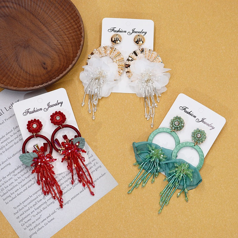Colorful floral earrings displayed on neutral background