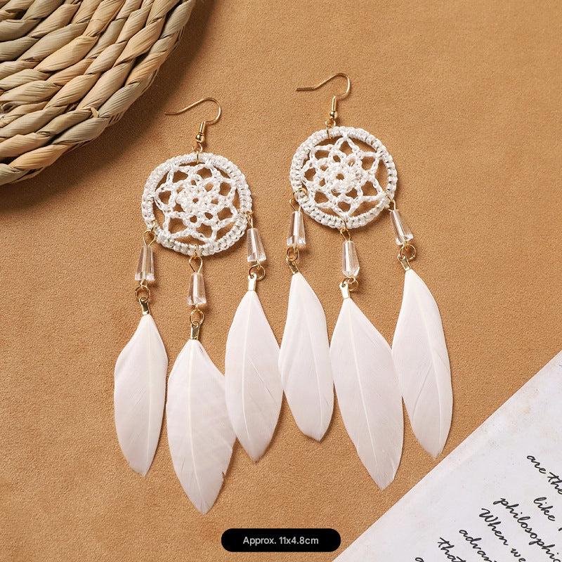 close-up of white bohemian feather earrings