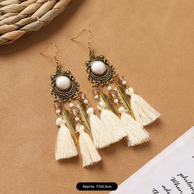 close-up of white bohemian feather earrings