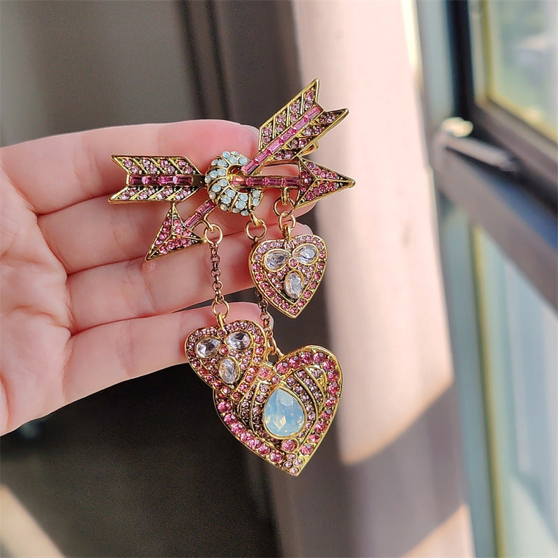 Close view of the colourful Cupid heart arrow brooch