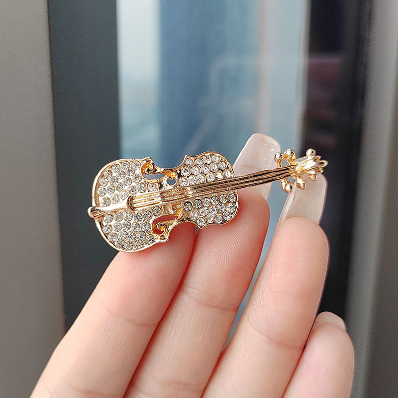Close up of silver oil drop violin brooch
