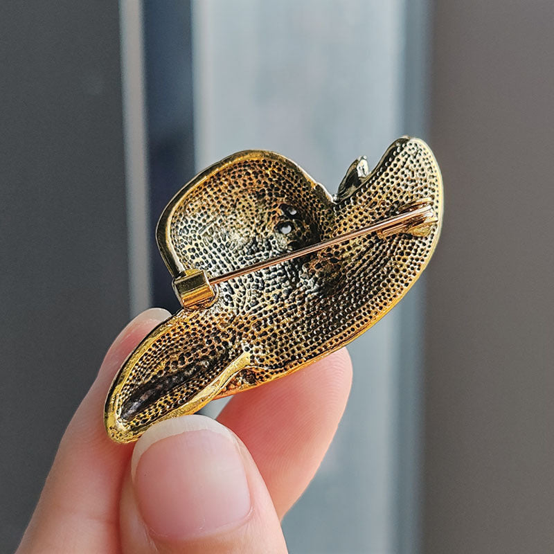 Gold alloy brooch on a fashionable hat