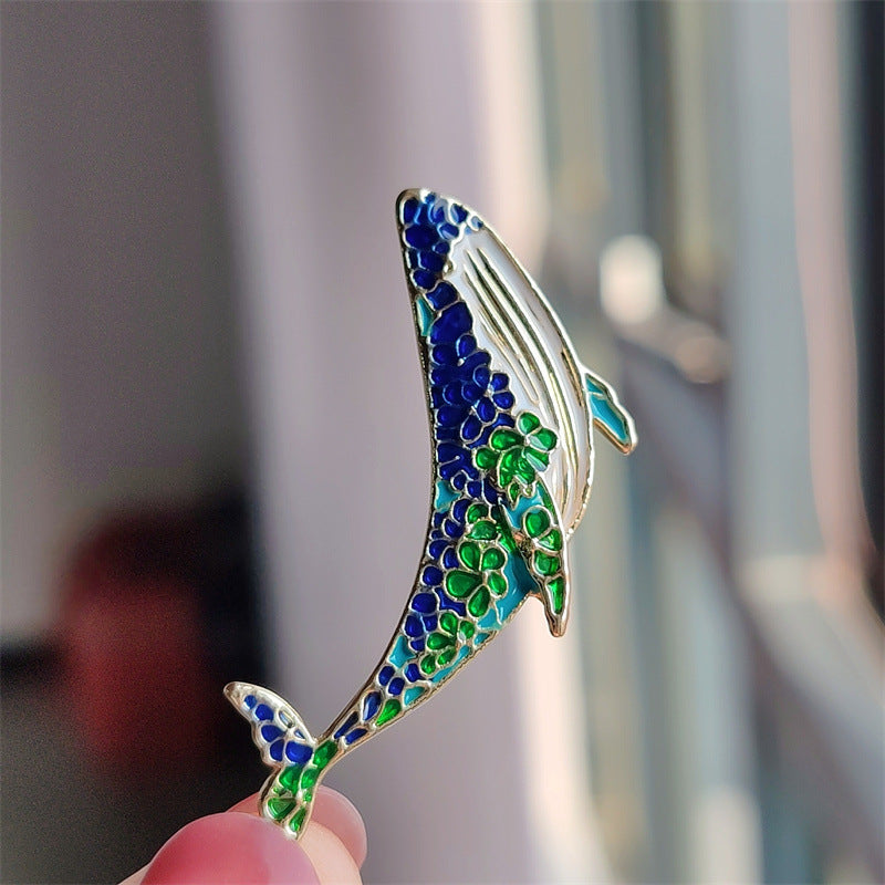 Elegant whale and dolphin brooch showcasing marine life design