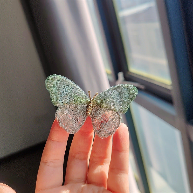 Green butterfly embroidered brooch displayed