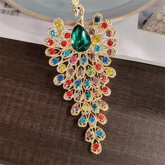 Vibrant peacock brooch in emerald gold