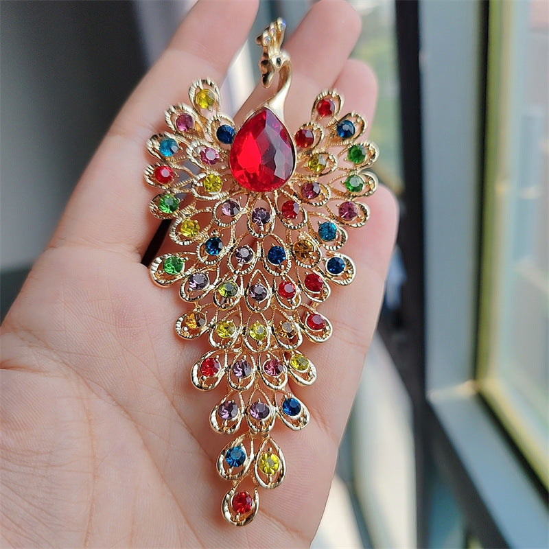 Vibrant peacock brooch in emerald gold