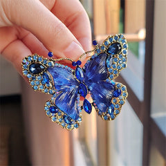Green butterfly brooch accessorising winter outfit