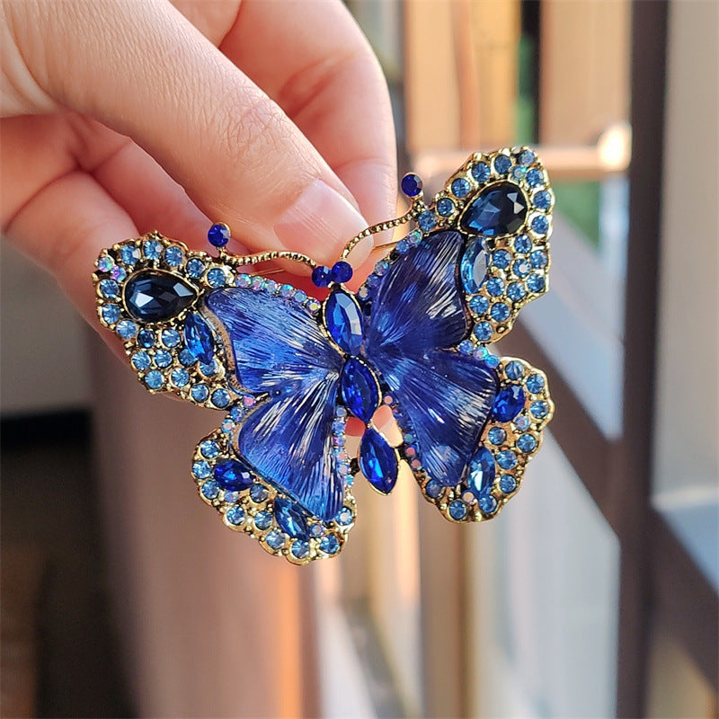 Green butterfly brooch accessorising winter outfit