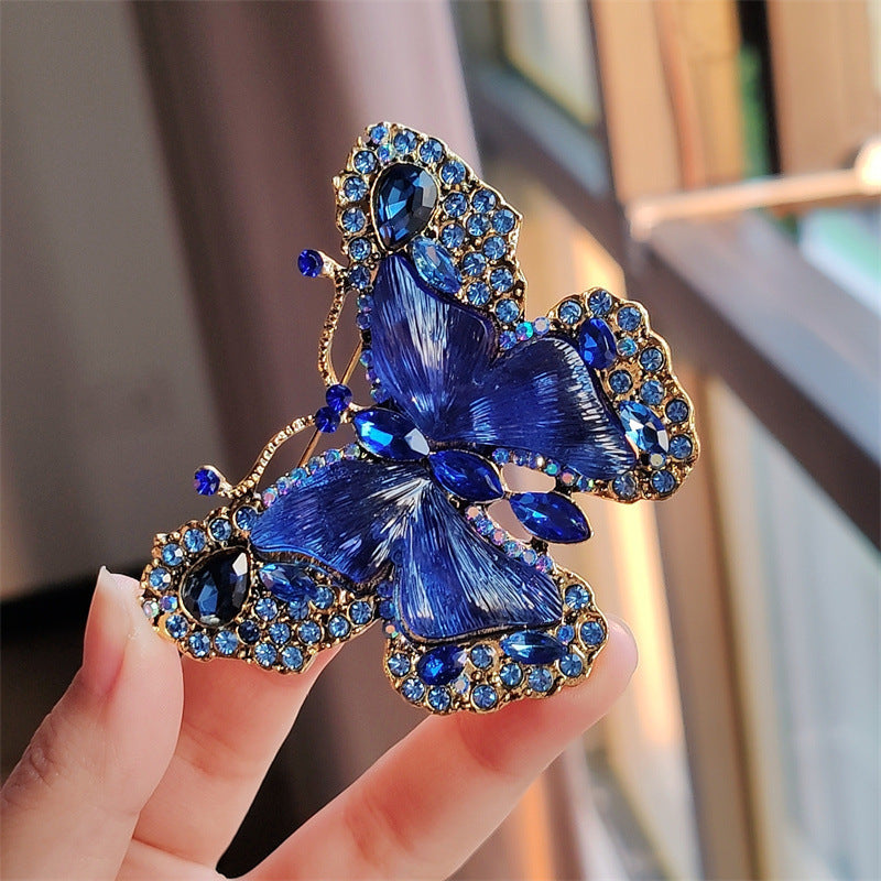Green butterfly brooch accessorising winter outfit