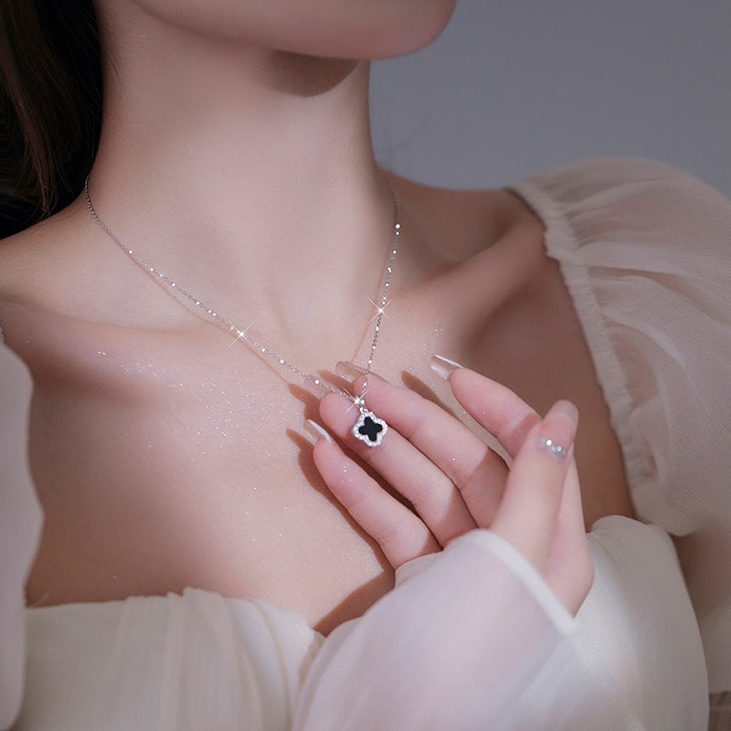 Gold four-leaf clover necklace on a soft background