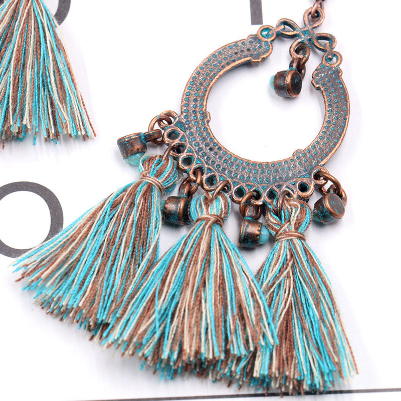 women wearing matching outfit with tassel earrings