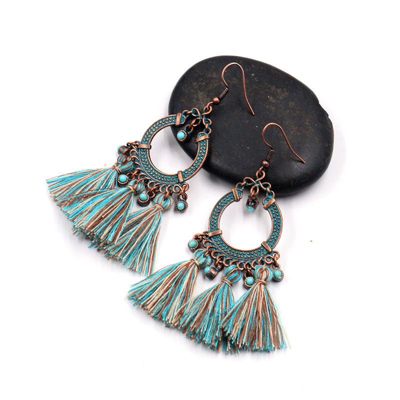 stylish earrings placed on a soft fabric background