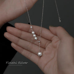 Close-up of pearl detailing on the silver necklace