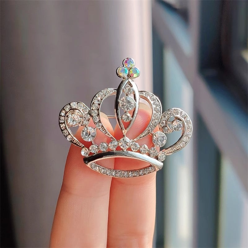 Close-up of gold rhinestone crown brooch