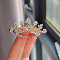 Golden crown brooch showcasing rhinestones