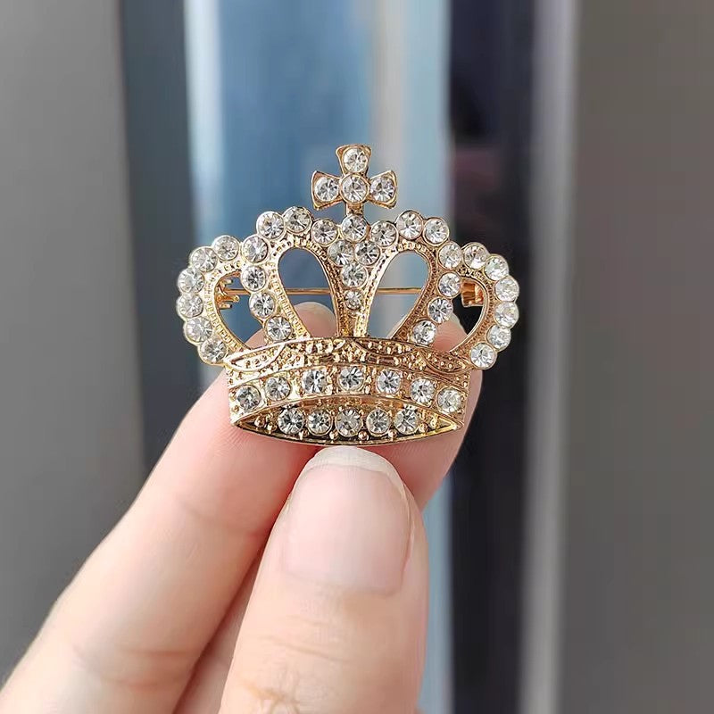 Silver crown brooch on black background