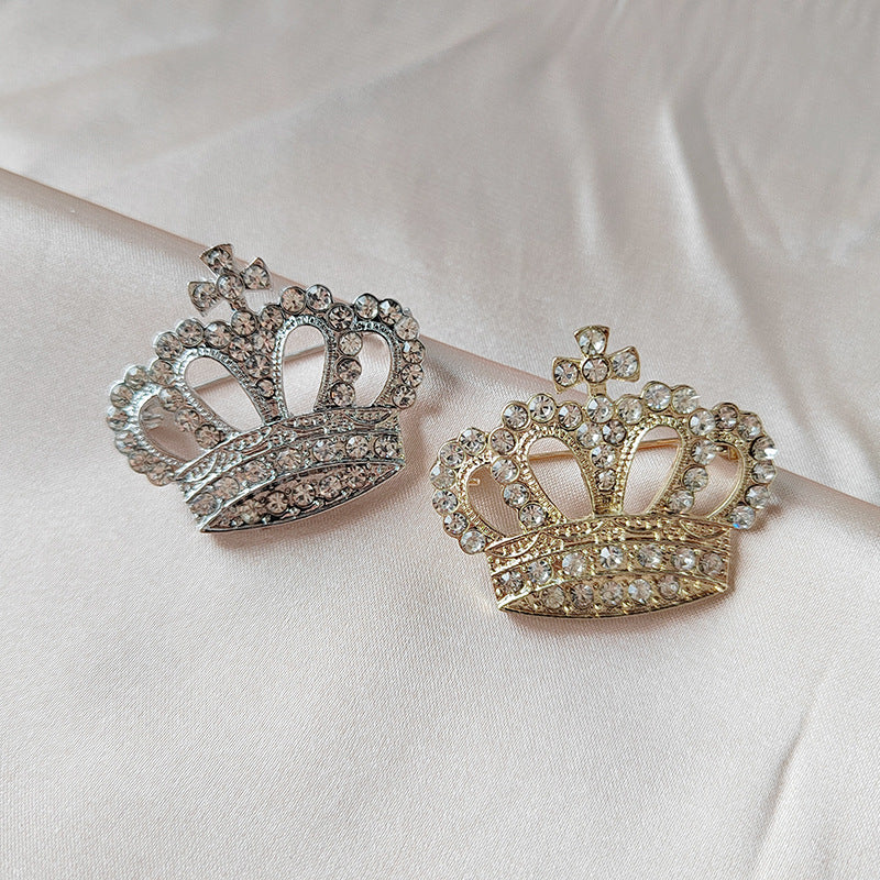 Silver crown brooch on black background