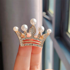 Golden crown brooch showcasing rhinestones