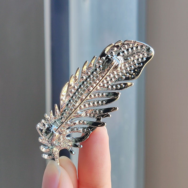 stylish feather brooch with intricate design and shimmer