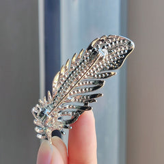 stylish feather brooch with intricate design and shimmer