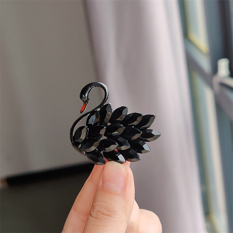 Stylish swan brooch pin displayed on a coat