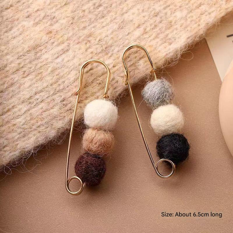 Multifunctional cardigan brooch displayed on fabric